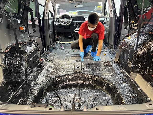 1665453490751242049.jpg 5.改装师正在用滚轮工具将隔音材料牢牢压实.jpg